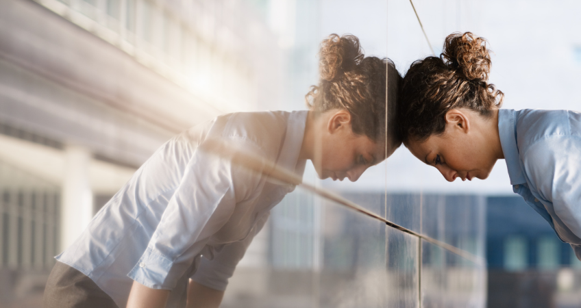 Woman with her head against the wall in frustration motivation