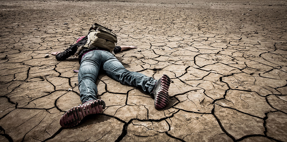 Man lying down in the desert.