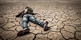 Man lying down in the desert.