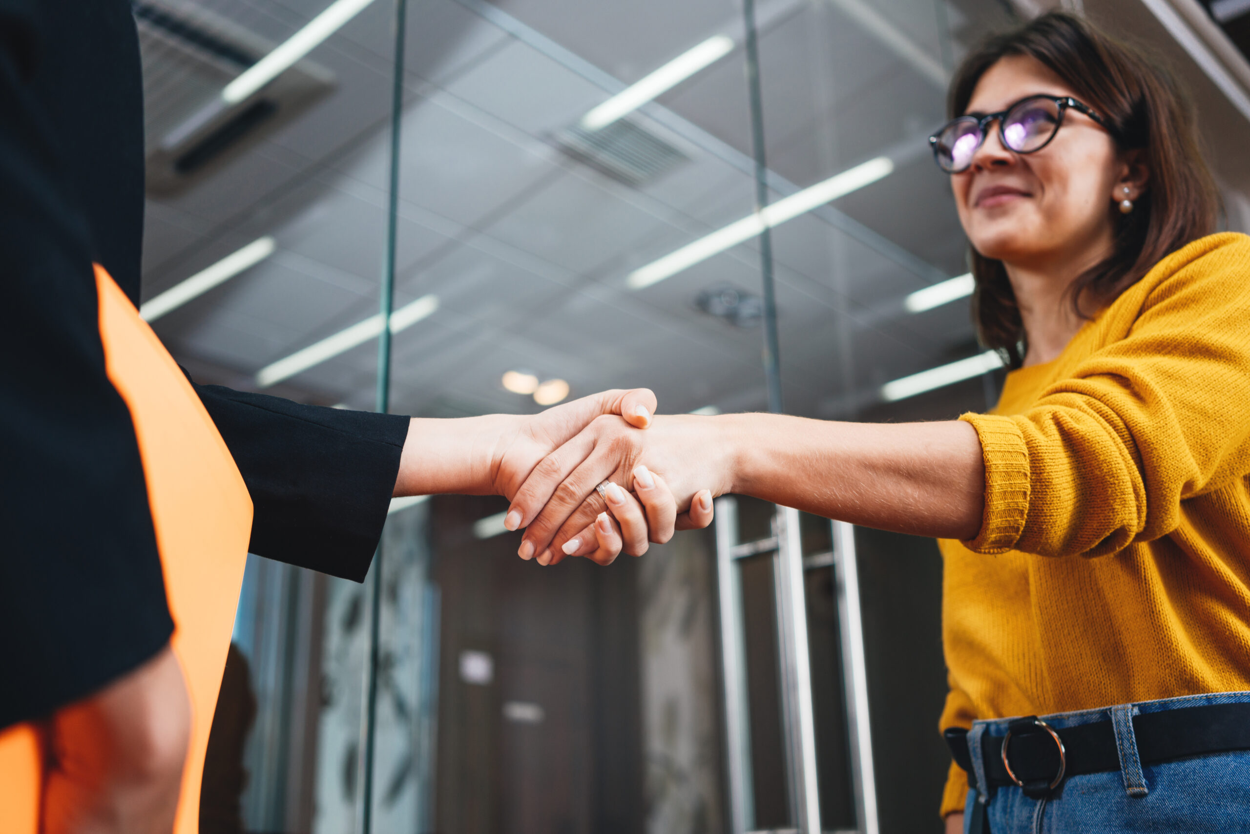 A female fundraiser shaking hands with a donor [How to Reimagine Your Money-Related Job Title]