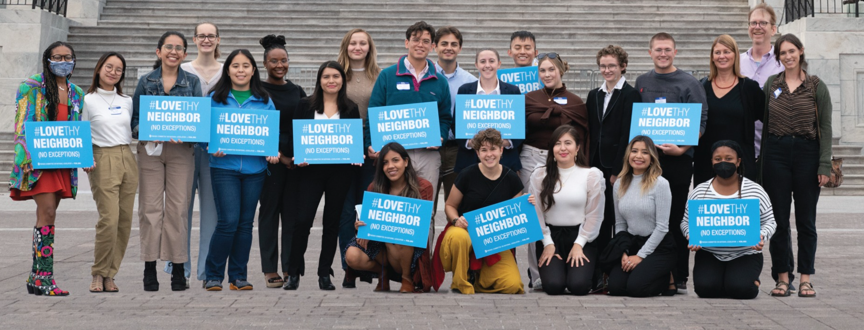 Staff members for the Friends Committee on National Legislation hold signs that say "Love Thy Neighbor."