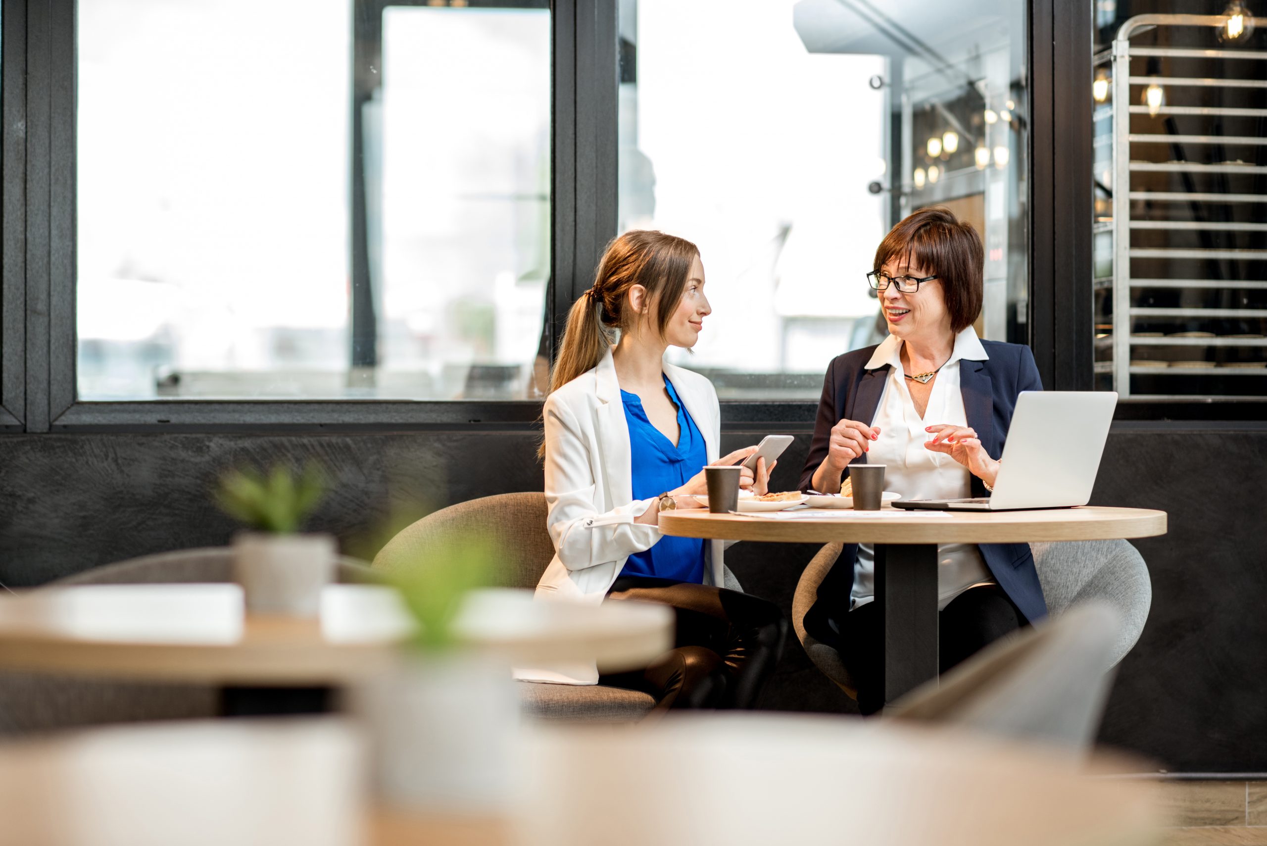 A fundraiser is meeting with her coach at a coffee shop.