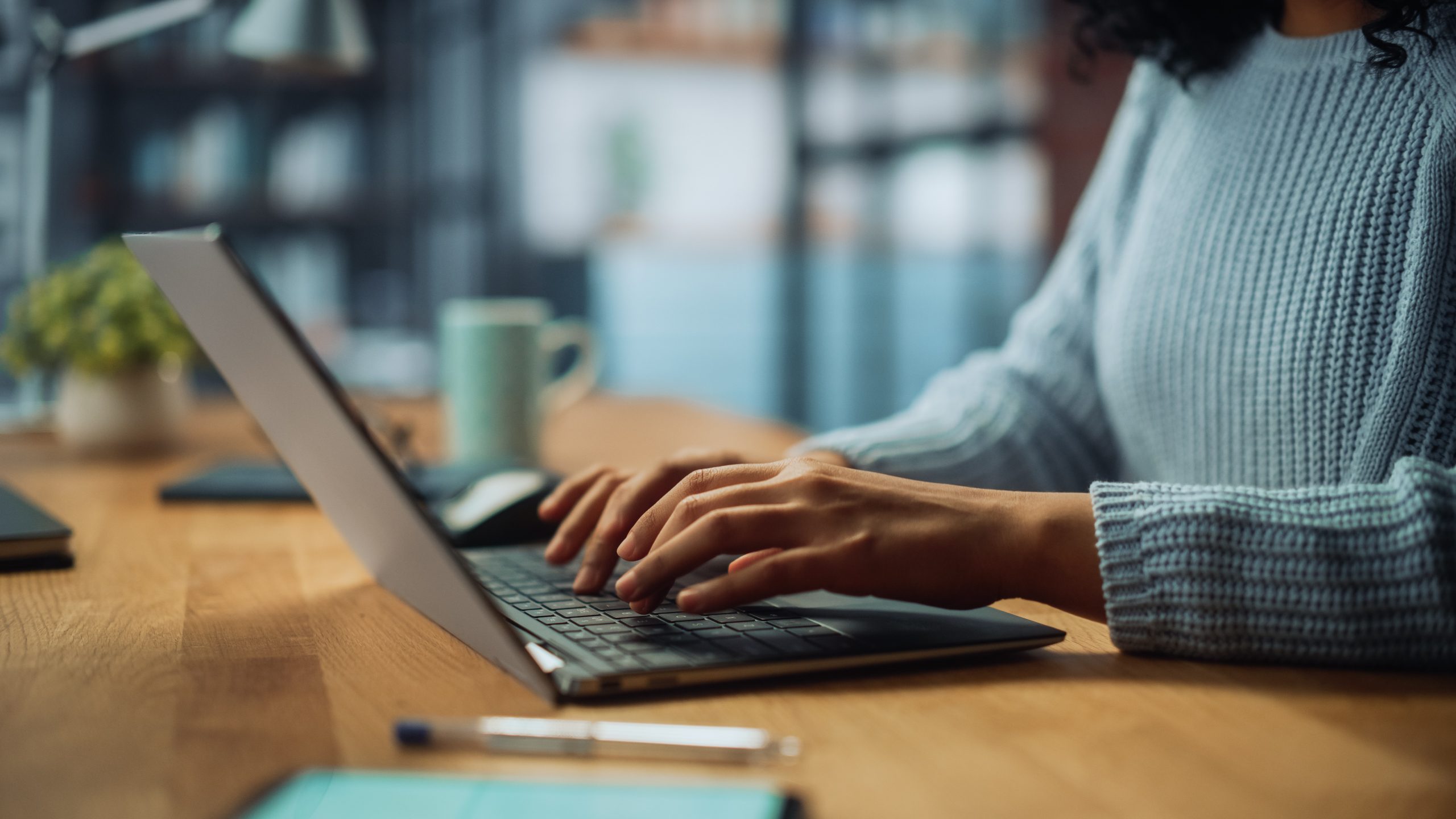 A close-up of a woman's hands on her laptop as she researches online will services.