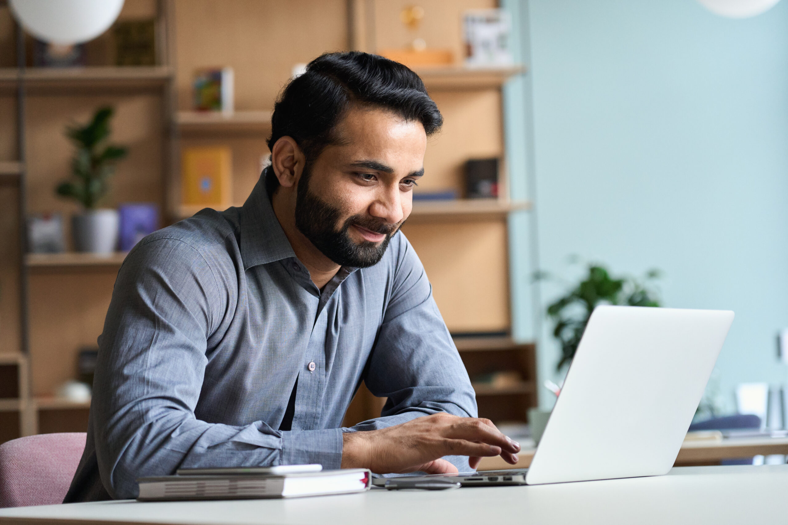 Smiling man working at a laptop. [Why Being a Frontline Fundraiser is NOT Just a Career]