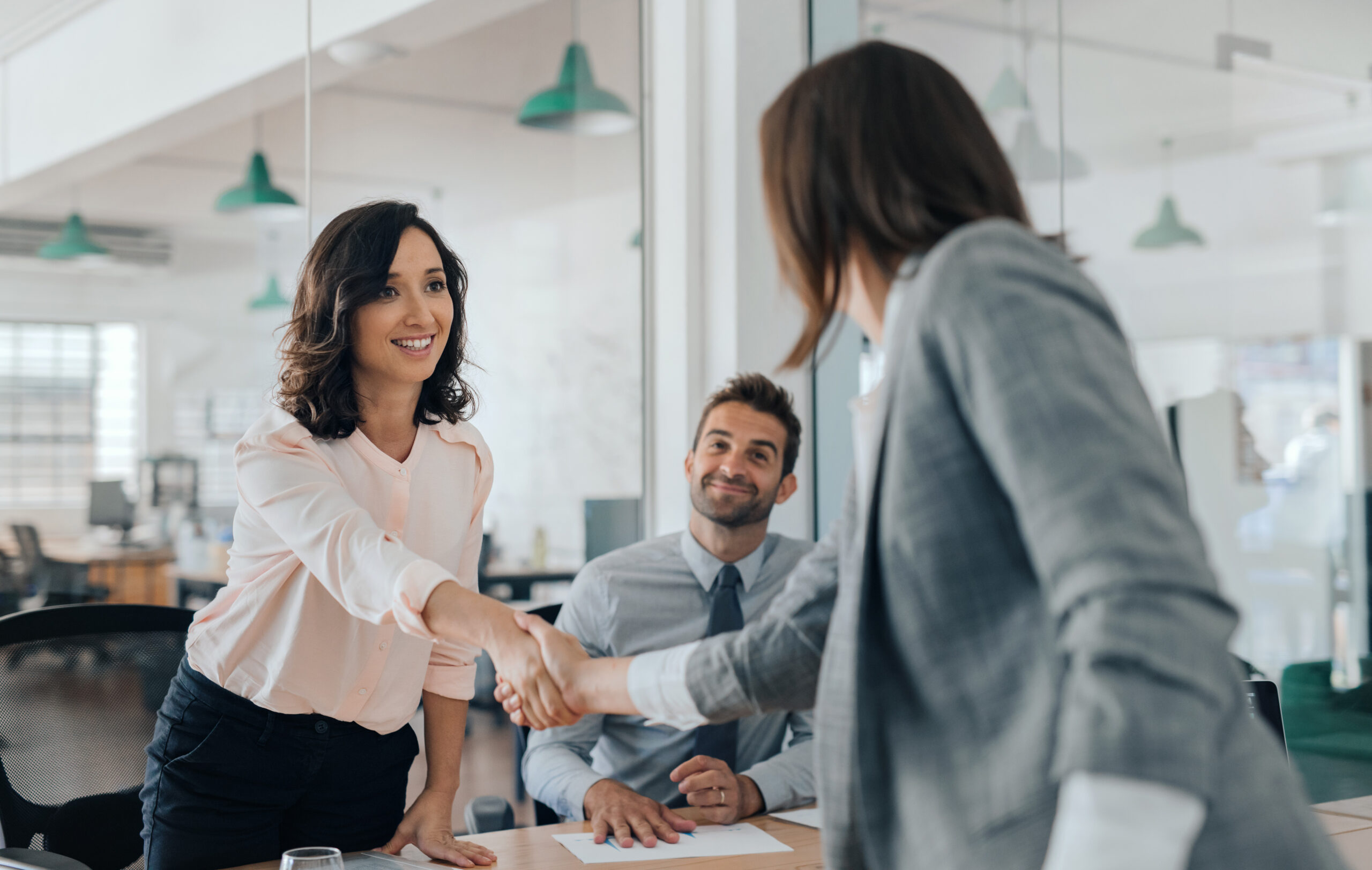 Women shaking hands at a donor meeting. [Improve Your Donor Relationships By Focusing on This ONE Thing in 2023]