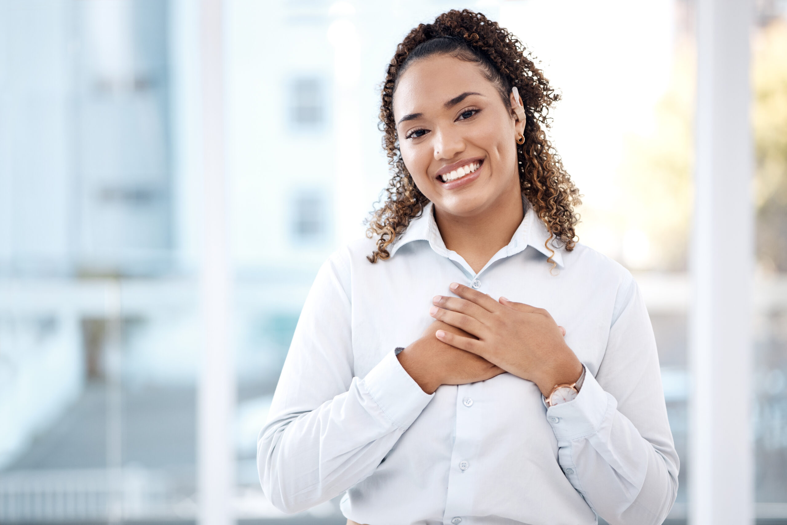 Woman smiling with her hands over her heart, showing her connection to her passions and interests [Have you identified YOUR Passions and Interests?]