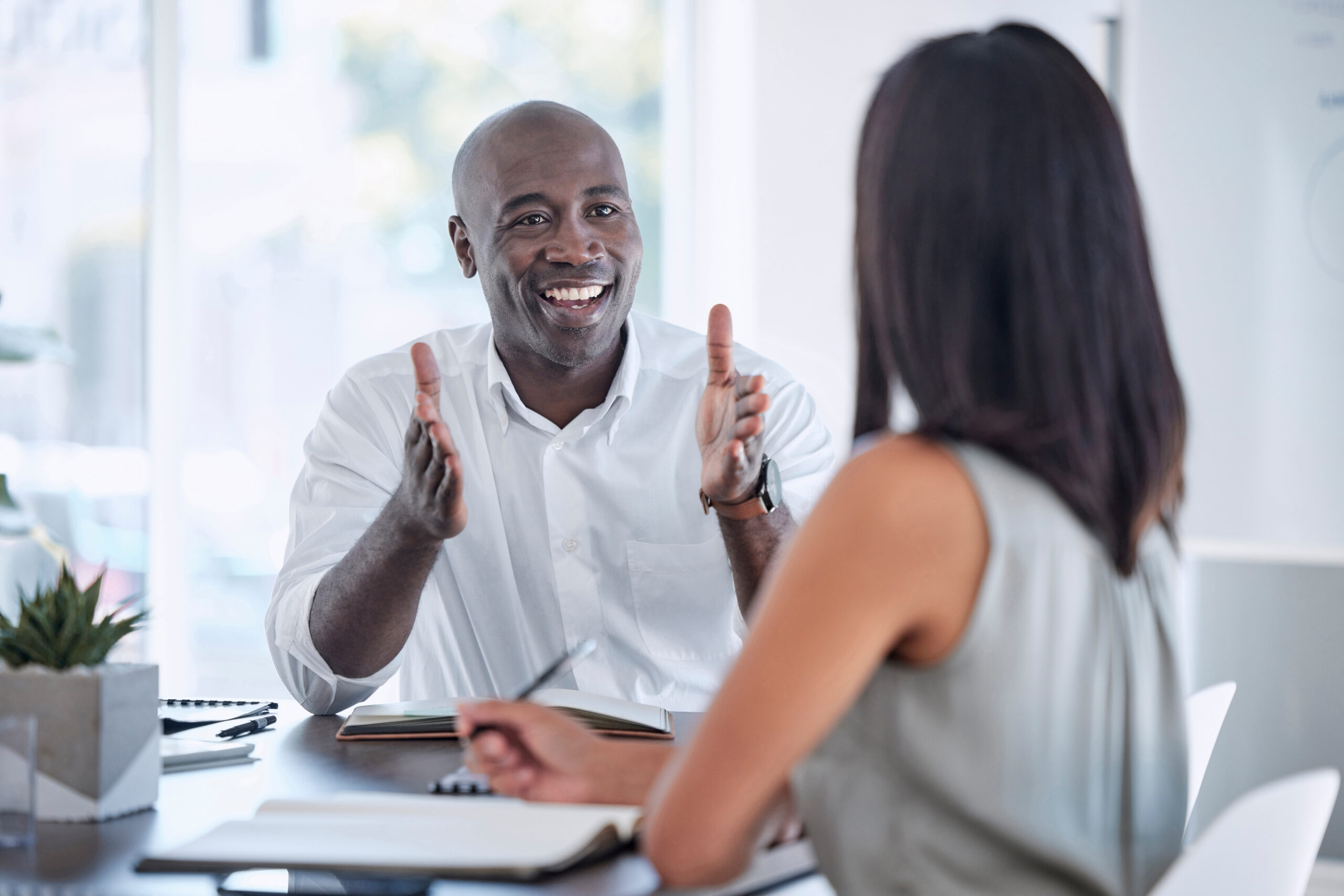 A non-profit manager meets with a frontline fundraiser in a modern office to offer encouragement and counsel. [In a Concerning Economic Environment, You Must Allow Your Fundraisers to Work Their Plan]