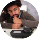 Businessman at his desk, staring at his phone.