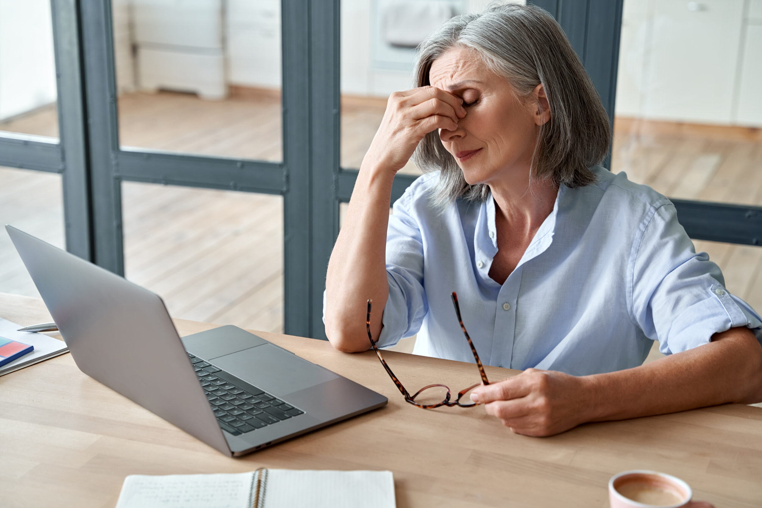 Mature woman suffering from fatigue rubs her eyes while sitting at computer [How to Handle Donor Fatigue]