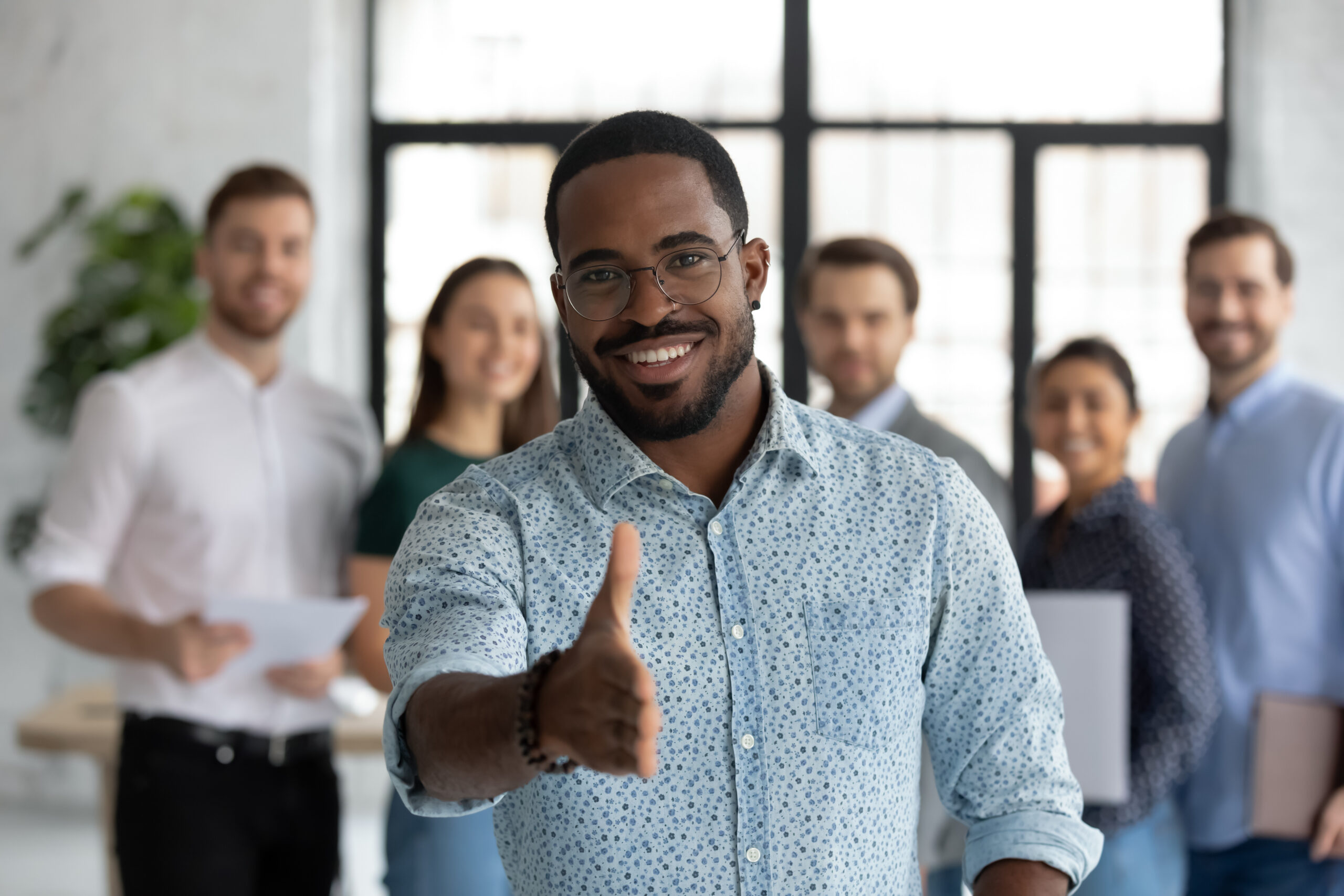 Man extends hand to welcome donor as partner. [Your Donors are ALSO Your Mission].