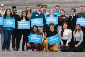 Staff members for the Friends Committee on National Legislation hold signs that say "Love Thy Neighbor."