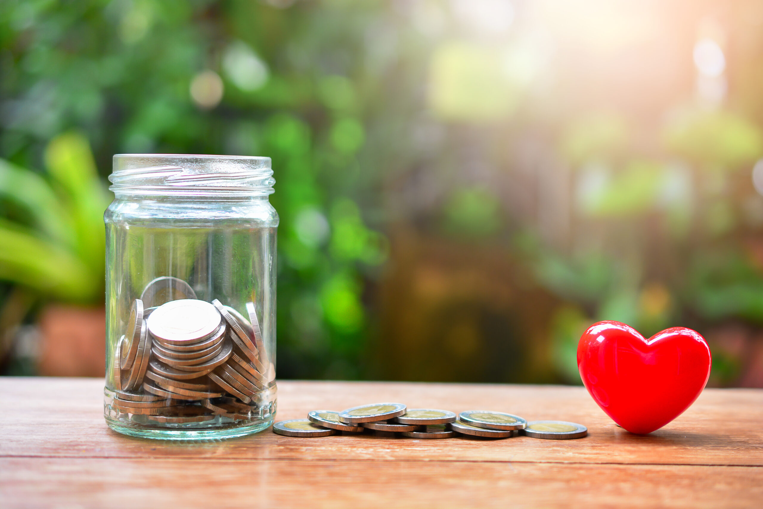 Glass jar with coins set with heart model for concept of giving capacity. [Donors Will Not Give to Their Capacity Unless You Deal With This One Thing]