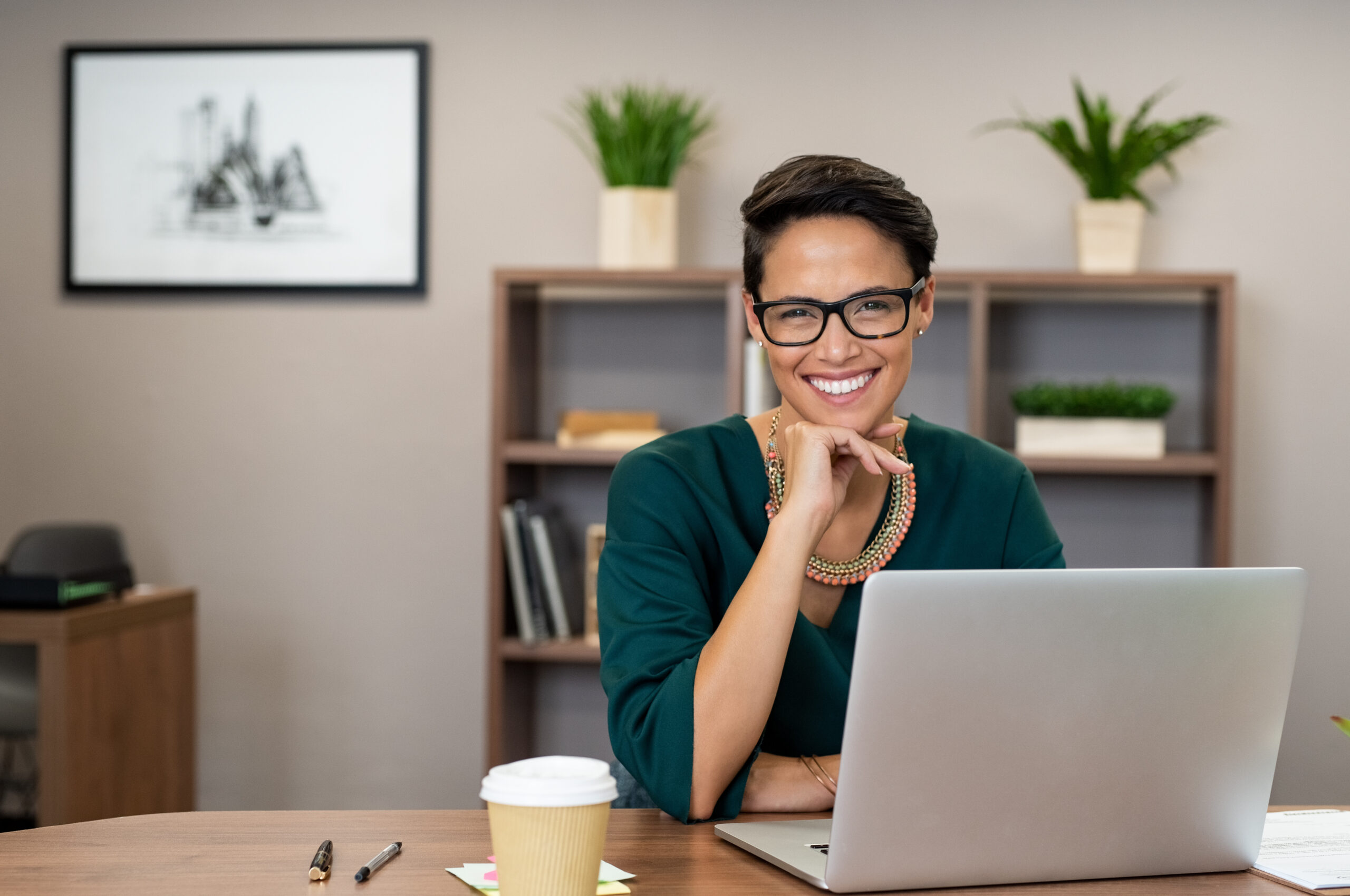 A woman is working at her desk and smiling [Do You LOVE Your Mission?]